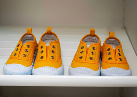 childrens red rubber fashionable sneakers stand in a row on the shelfの写真素材