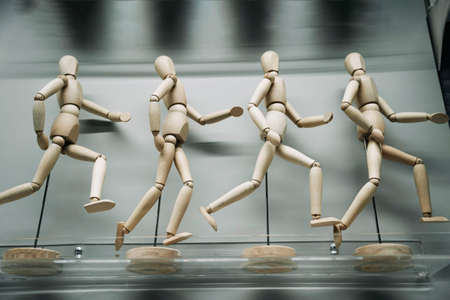 wooden figures of people running after each otherの写真素材
