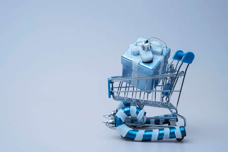 a supermarket trolley stylized as a sled carries boxes with gifts for Christmasの写真素材