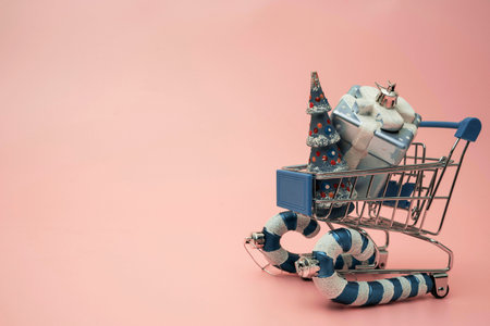a supermarket trolley stylized as a sled carries boxes with gifts for Christmas