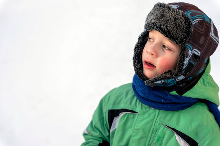 Funny Caucasian boy of 5 years old dressed in warm winter sports clothes