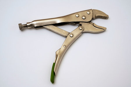 open locking pliers on a white background. Artisans hand tool close-up