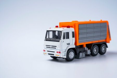 Toy car garbage truck with orange body, on a white backgroundの写真素材
