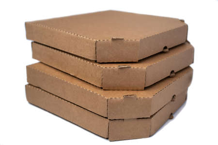 Stack flat brown cardboard pizza boxes isolated on a white backgroundの写真素材