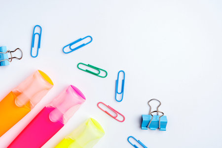 stationery, orange and yellow text highlighters, paper clips and documents