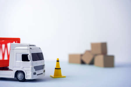 a truck and a lot of cardboard boxes for delivery, copy space on a blue background. idle trucks due to lack of fuelの写真素材