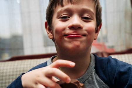portrait of a funny cute Caucasian boy who eats chocolate