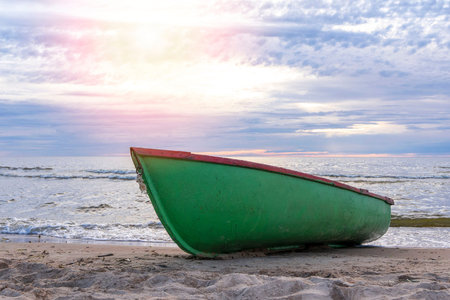 wooden fishing boat pulled onto the sand of the shore of the sea bayの写真素材