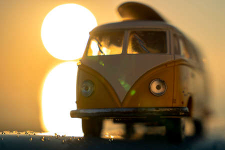 minibus with surfing on the roof in the rays of the setting sunの写真素材