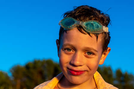 Portrait of boy in swimming glasses who smiles and looks at the cameraの写真素材