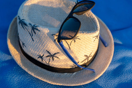 sun hat and sunglasses on a beach blanket. concept of summer holidaysの写真素材