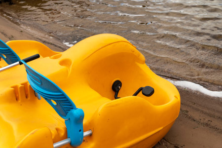 Funny colored plastic catamaran on the lake shore. Summer holidays