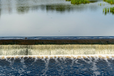 dam on a small river. Water flows from a small river dam, boils, foams