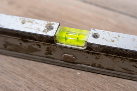 used bubble construction level lying on a ceramic tile floorの写真素材