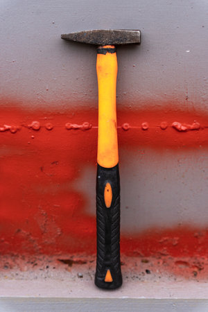 small iron hammer with a long plastic handle on a shelf in workshopの写真素材