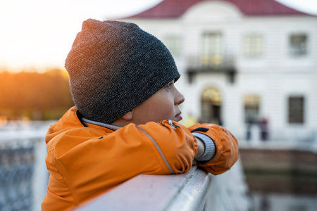 the boy looks into the distance with his chin on his handsの写真素材