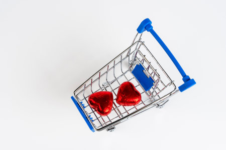 Supermarket trolley loaded with heart-shaped candiesの写真素材