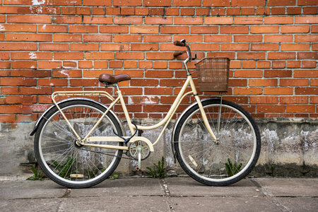 ladys city bike with a basket leaning against the brick wallの写真素材