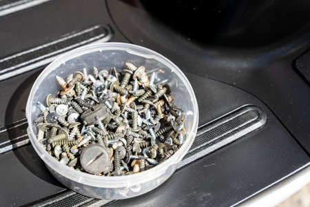 Metal fasteners, bolts, screws, nuts, washers in a box in the workshop