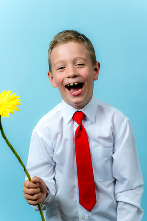 first grader with a backpack holds a bouquet of flowers