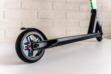rear wheel and brake of a Stunt scooter with rainbow-colored wheels
