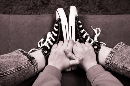 Teenagers feet in casual new sneakers on the sofa