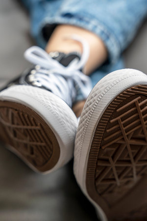 soles of new youth sneakers with lacing worn on a girl