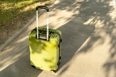 large green suitcase on wheels and with a telescopic handleの写真素材
