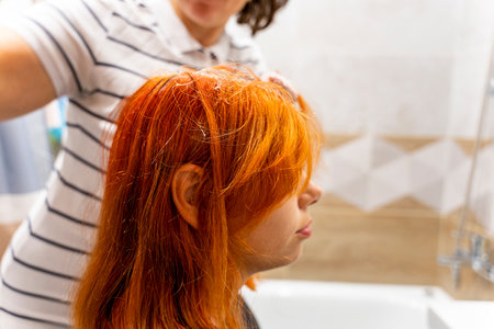 Profile of a pretty teenage girl coloring her hair redの写真素材