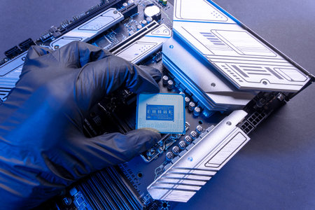 computer processor in a gloved hand against the background of the motherboard