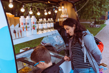 KRONSTADT, RUSSIA - SEPTEMBER 23, 2023: mom and son buy fast food in Food Truckのeditorial素材