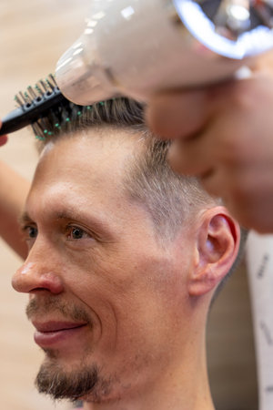 professional hairdresser cuts a mans hair. visit to the barber shopの写真素材