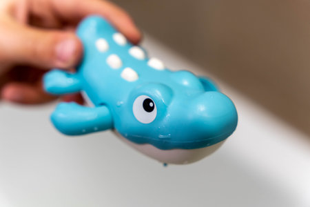 alligator for the bathroom in the hands of a child. A toy for bathing toddlersの写真素材