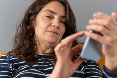 relaxed woman on a home sofa with her smartphone on a social network