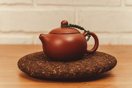 Yixing clay teapot for tea brewing, accompanied by pressed pu-erh black tea discの写真素材