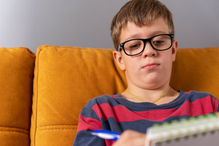 boy concentrating on drawing in his notebook in a moment of creative inspirationの写真素材