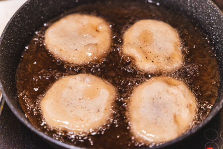 Raw belyashi with meat, baked in boiling oil in a frying pan traditionalの写真素材