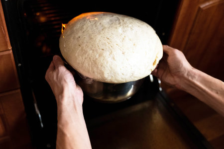 Mans hands kneading dough for bread in the oven with sourdough and heat