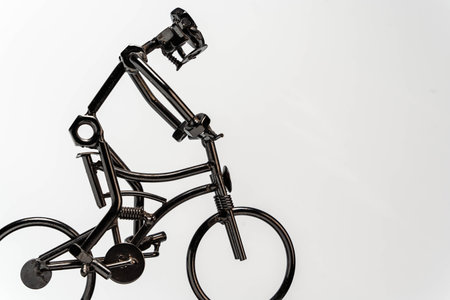 detailed metal parts sculpture depicting a cyclist, isolated on a clean white background with plenty of copy space, perfect for cycling or sports-related concepts and designsの写真素材