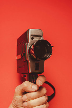 vintage portable movie camera in the operators hand. retro, 70s, 80s