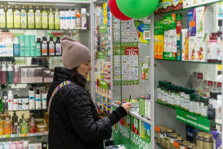 Russia, Sosnovy Bor, April 25, 2024 - a woman buys medicines and medicines at a pharmacyのeditorial素材