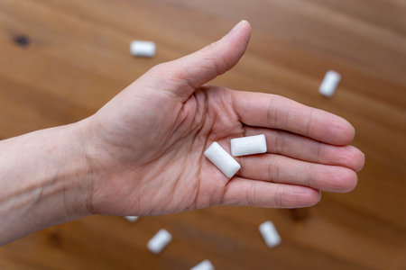 Fresh breath and oral hygiene concept with two chewing gum pads on womans palm