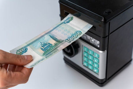 Individual inserting cash into automated teller machine.の写真素材