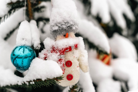 A snowman decoration hangs from a Christmas tree.の写真素材