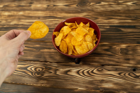 Hand of a person holding a potato chipの写真素材
