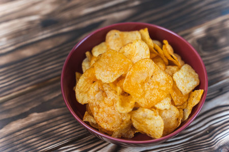potato chips on a wooden table, unhealthy food