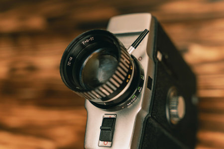 Close-up of a vintage film camera lens on a wooden background, 8mm