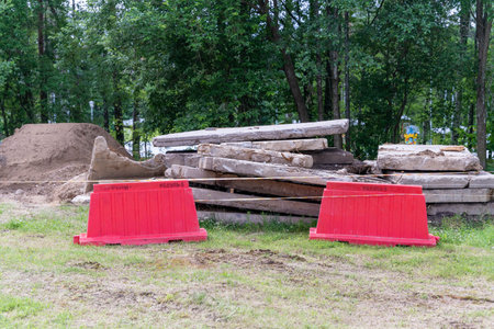 Red barriers in front of concrete slabs in a grassy areaの写真素材
