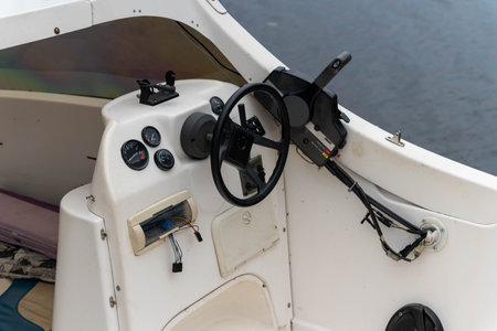 Boat dashboard and steering wheel captured during a calm eveningの写真素材