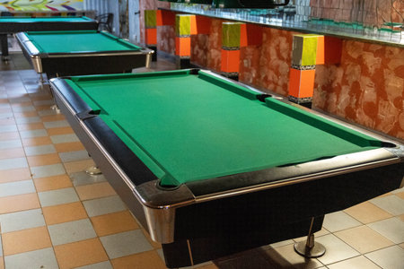 Several empty pool tables with bright colored decor in the backgroundの写真素材